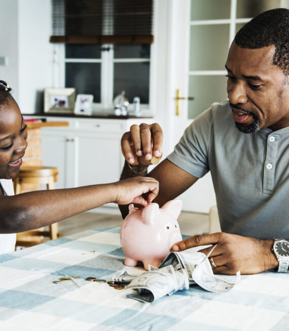 Dad and daughter saving money to piggy bank Dad and daughter saving money to piggy bank